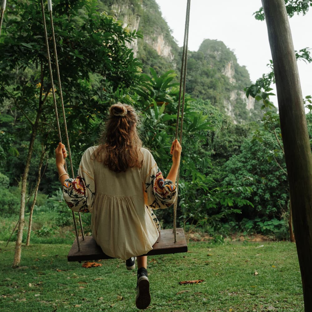 Sitting on a swing in front of the karst mountains