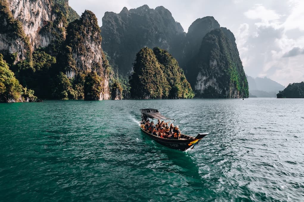 Long tail boat on Cheow Lan Lake with karst mountains in the background