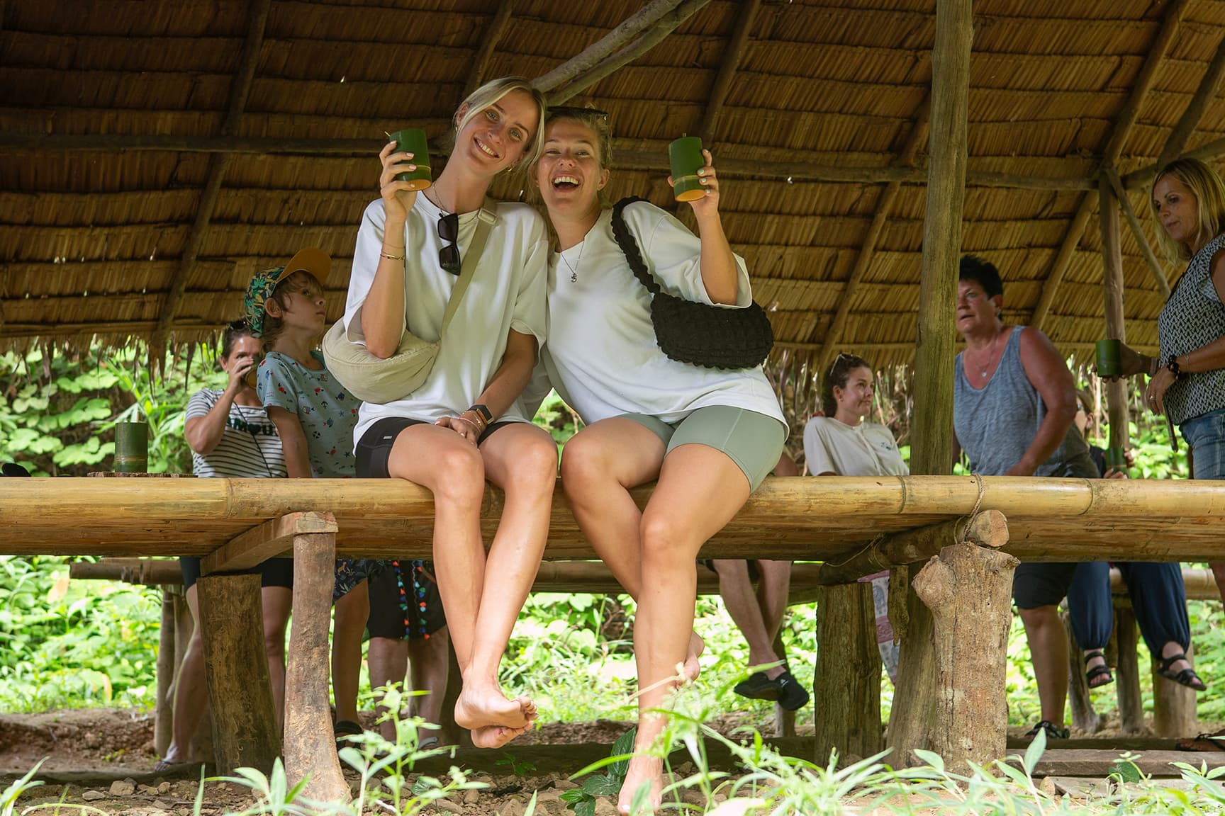 2 girls drinking coffee from bamboo cups 