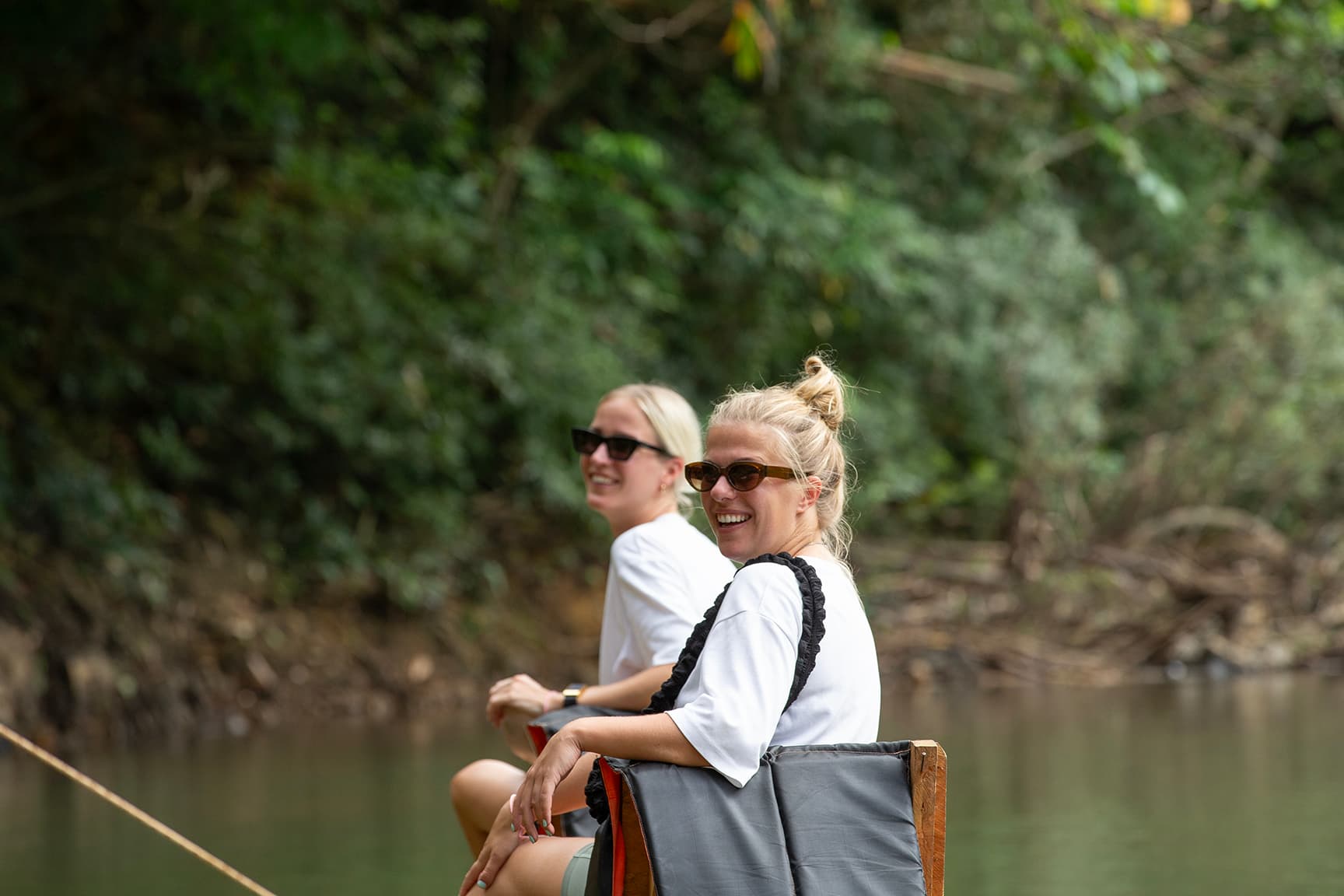 2 girls Floating down the river on a bamboo raft 