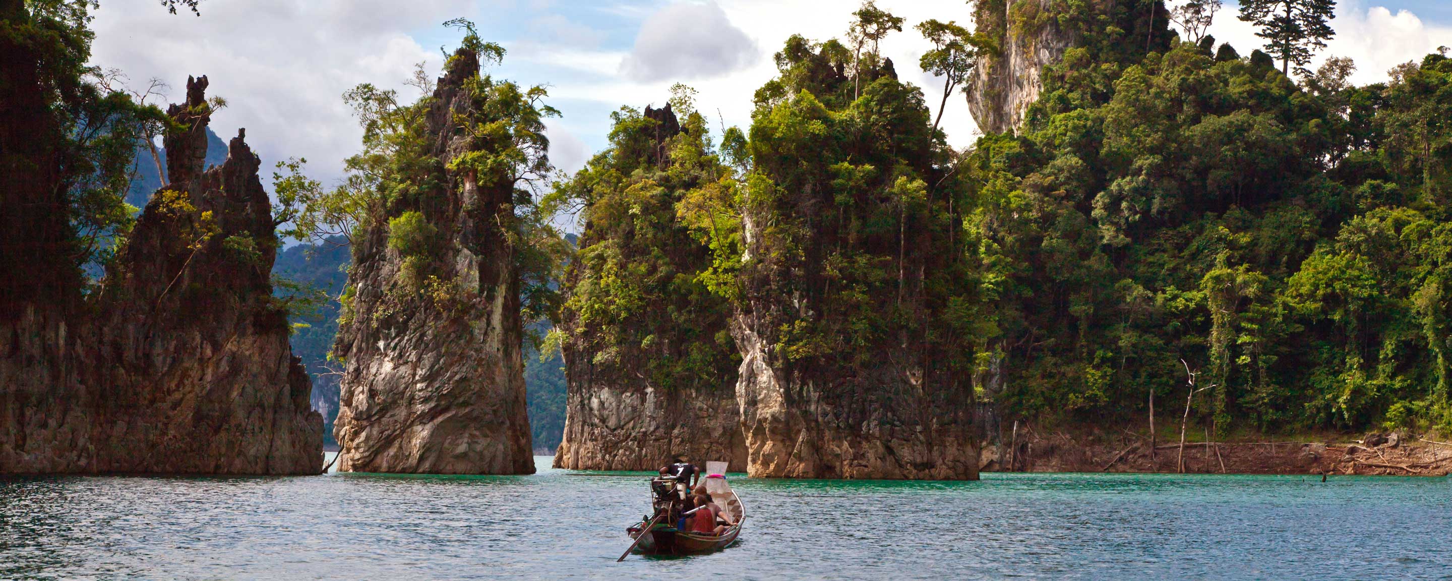 Karst mountains on Cheow Larn lake with long tail boat