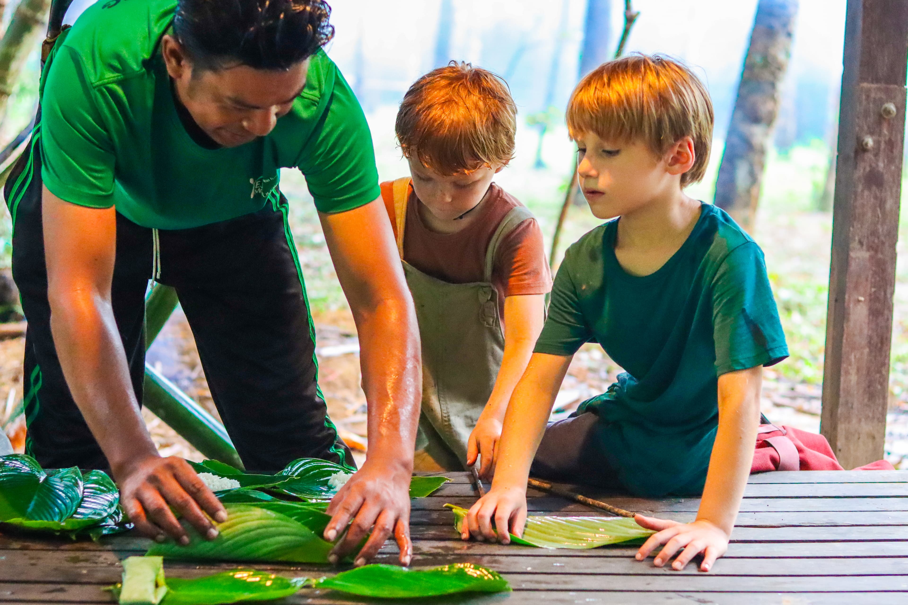 Kids learning to fold babana leaves